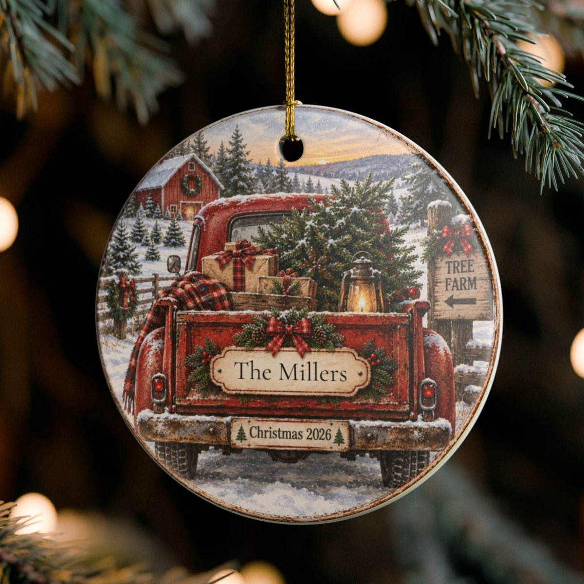 A round wooden Christmas ornament hanging from a pine tree branch with warm bokeh lights in the background. The ornament features a printed illustration of a red pickup truck carrying a Christmas tree and wrapped gifts, with a sign reading 'Name' and 'Christmas 2023'.