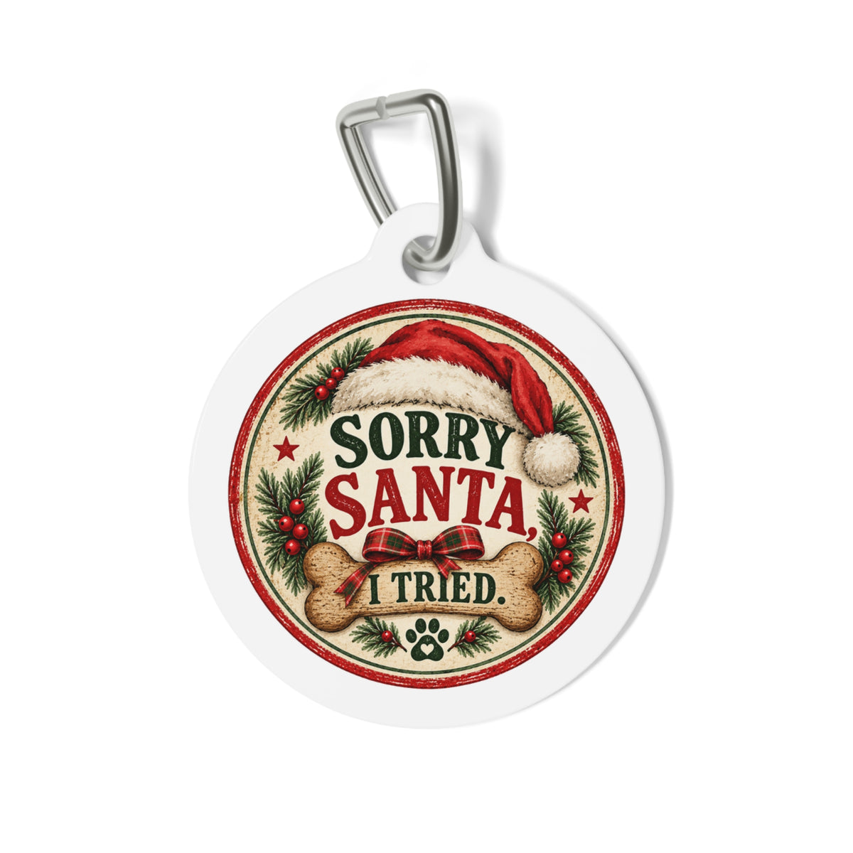 A round white pet ID tag with a silver metal clip, featuring a festive Christmas design that reads 'SORRY SANTA I TRIED.' with a Santa hat, red bow, holly leaves, and bones.
